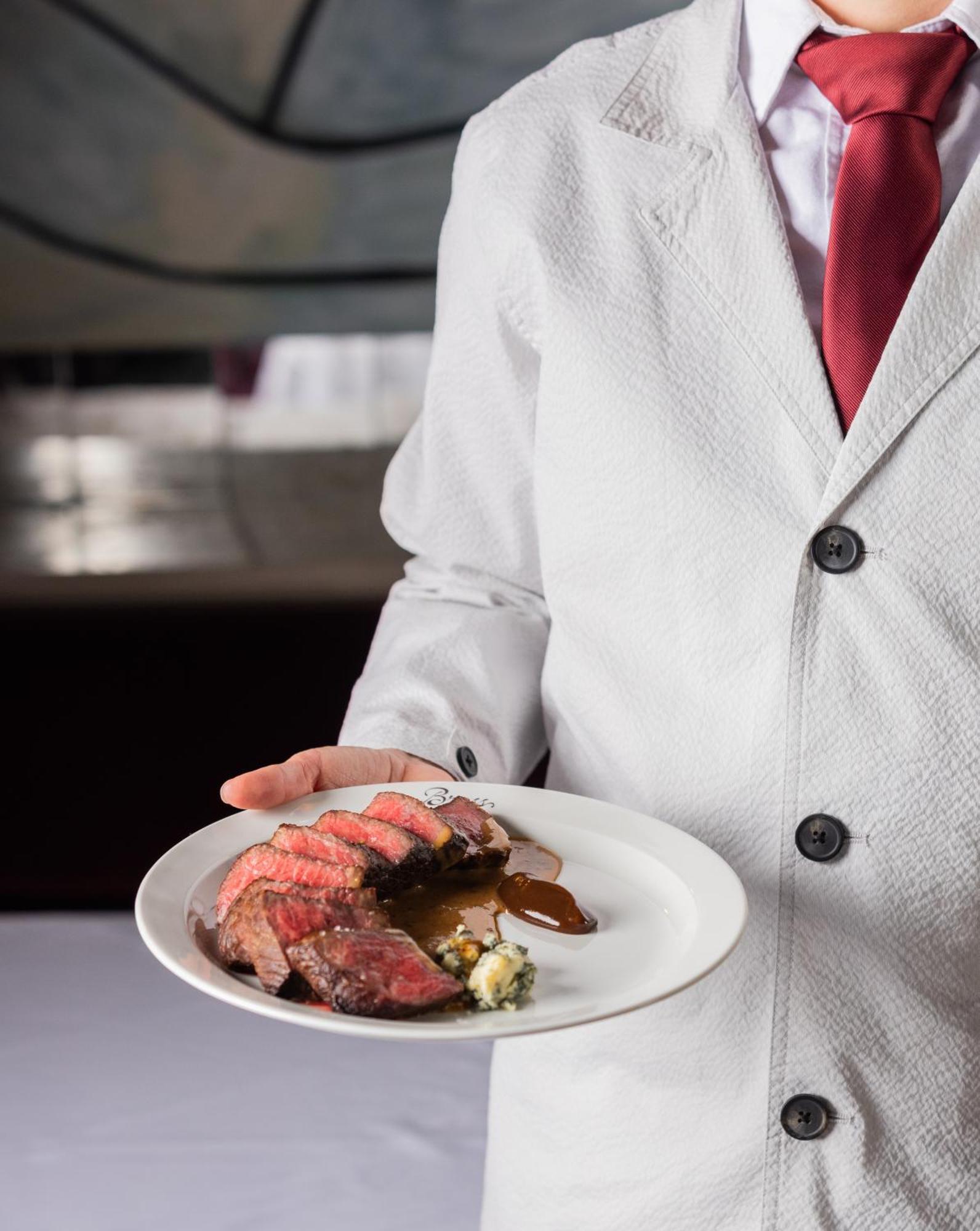 Hotel The Evelyn Nomad New York Esterno foto A waiter serving a steak